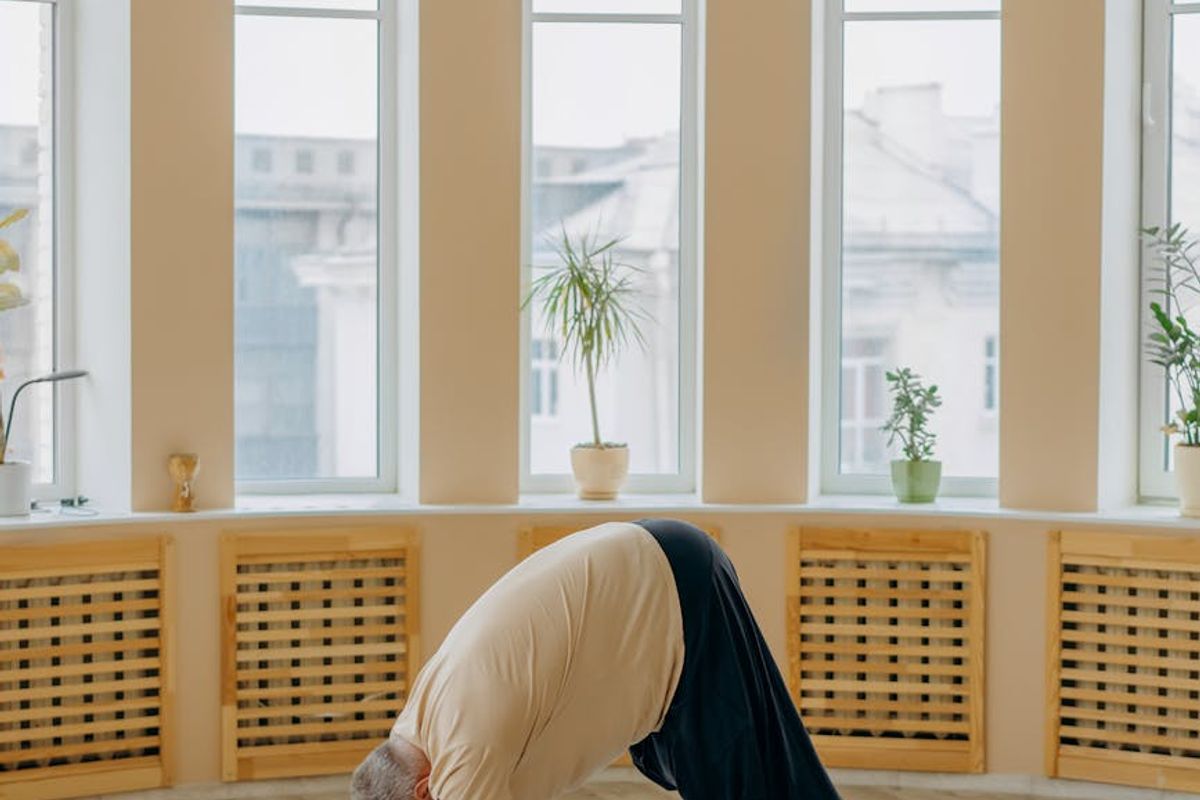 Spacious yoga studio with dark wooden floors and mats